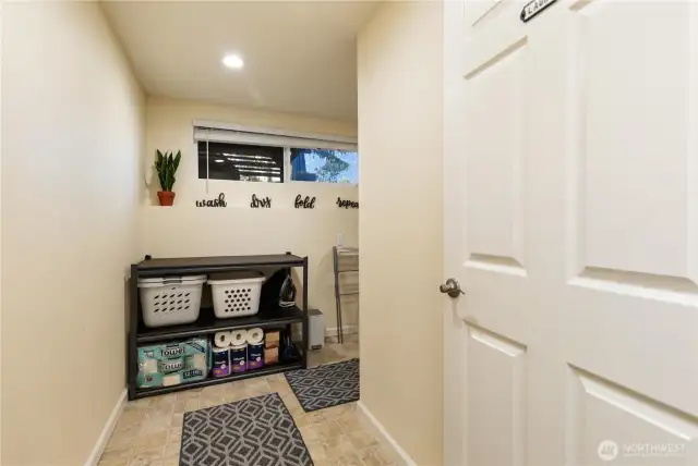Entering the laundry room, there is plenty of storage.