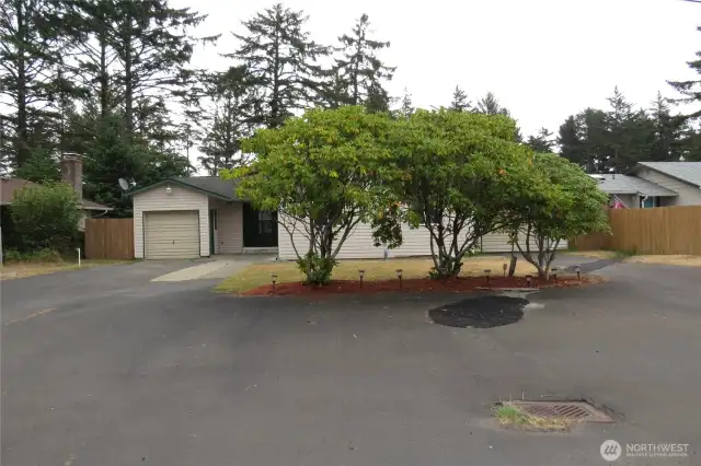 STREET VIEW OF THIS THREE BEDROOM TWO BATH HOME HAS PAVED PARKING UP FRONT AS WELL AS PAVED DRIVEWAYS TO EACH GARAGE!