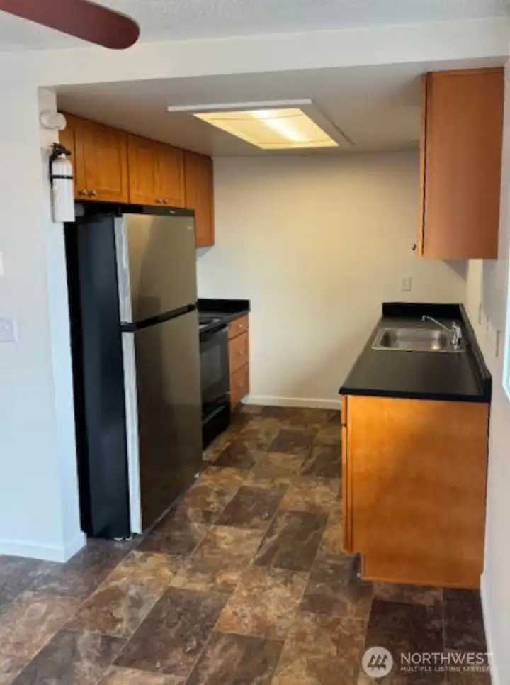 Unit 4 kitchen, stainless steel refrigerator, easy to clean countertops and plenty of storage.