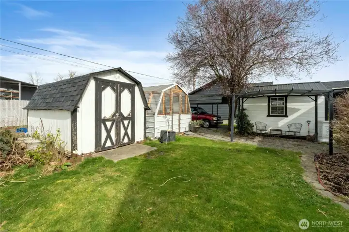 Storage shed, greenhouse and covered patio adjacent to the studio outbuilding.