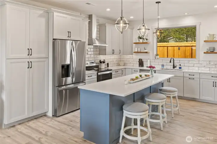 The eating bar at the kitchen island serves as a natural gathering space, perfect for casual dining, conversation, and entertaining.