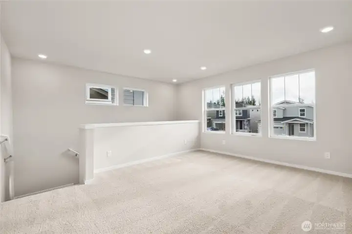 Spacious upstairs loft with large windows for natural light. Photos are representative only and may display different color packages and/or upgrades.