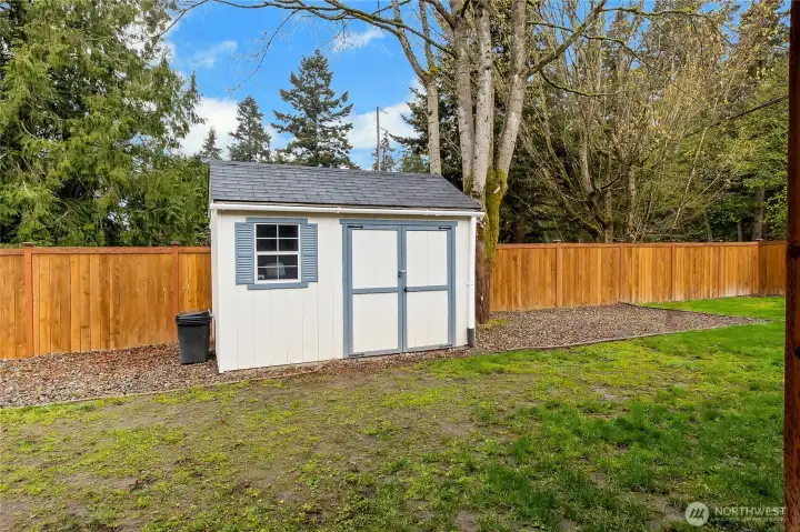 This lovely shed provides even more space for your things. Mature landscaping adds to the privacy.