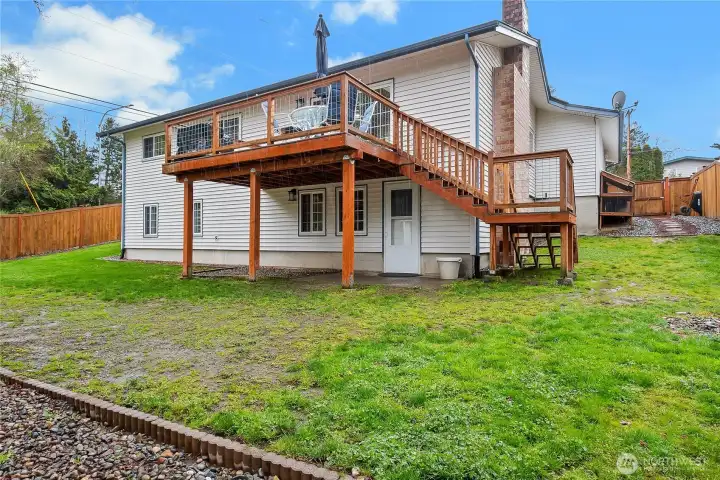 View of the back of the house along with the kitty condo set up to the far right and the trex-style decking of the back deck.