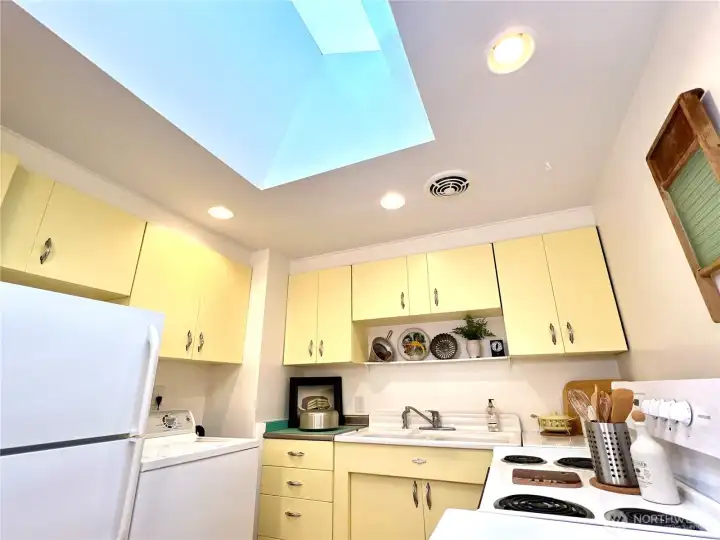 The kitchen skylight provides additional lighting throughout the day. Ceiling fan is above the stove