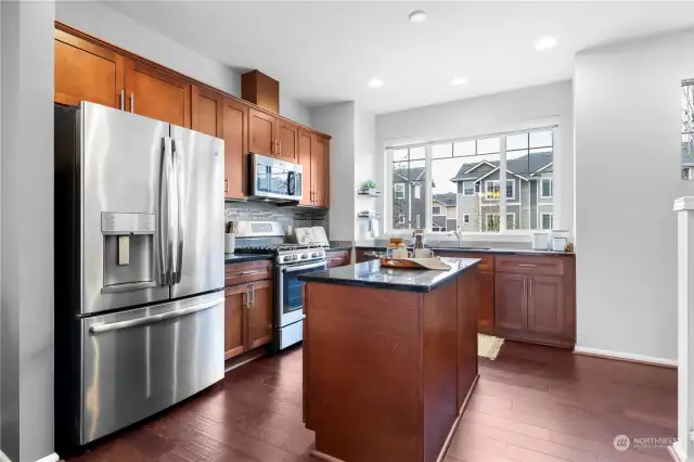 Kitchen offers upgraded appliances, granite counters, full backsplash, gas cooking and is wired for pendant lighting above the kitchen island!