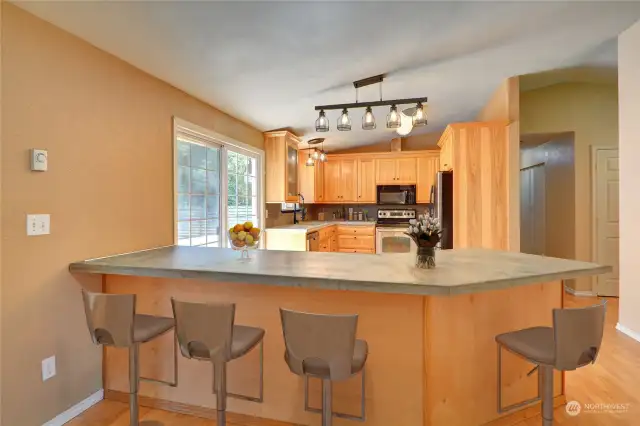 This kitchen is ready a chef's dream.  With concrete countertops, stainless appliances, Hickory cabinets, and plenty of room, it is top-notch!   Lot's of natural light, plus a slider to the deck and backyard.