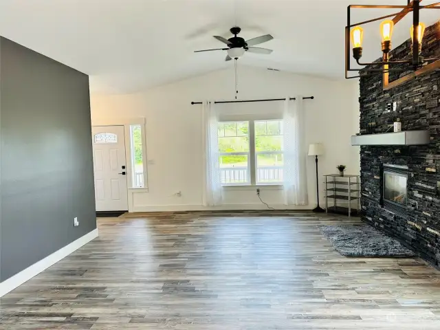 Light and Bright living area with stone stack propane fireplace