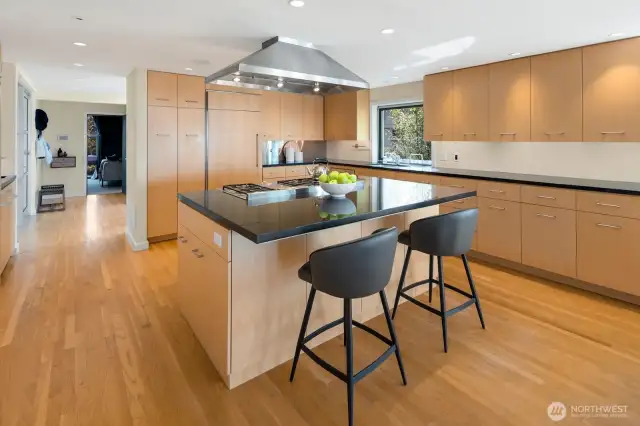 -A large granite island is the perfect centering element in a kitchen filled with useful details and scrumptious delicacies.