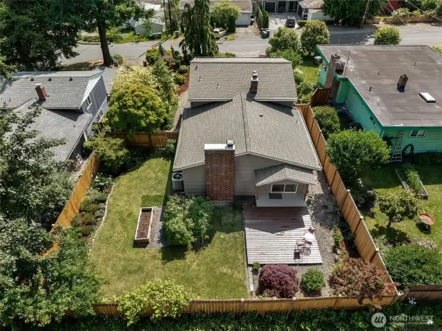 Aerial of the back of the home showing the beautiful flat, completely fenced in back yard here.