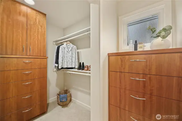 The primary walk-in closet with built-in drawers and shelving.