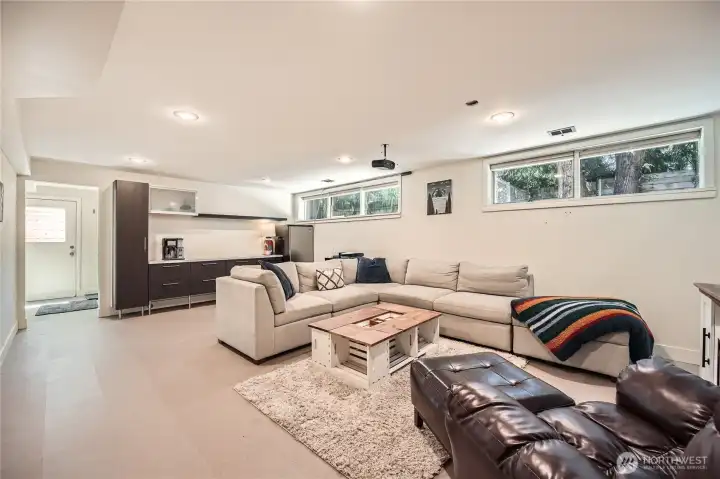 Spacious lower-level family and entertainment room offers the perfect retreat for movie nights, game days, or casual lounging. Featuring a convenient serving/eating bar, sleek built-ins, and a full bathroom, this inviting space is ideal for hosting or relaxing in style. Thoughtfully designed with daylight windows for natural light and a private entrance for added flexibility.
