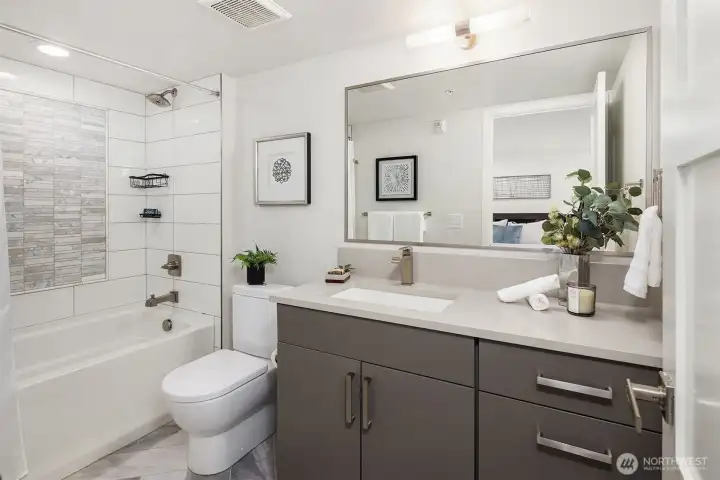 Ensuite bath features an oversized vanity and soaking tub with tile surround