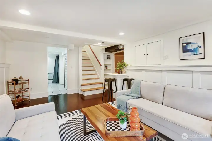 Rec room looking back at stairs and hallway to laundry room and half bath.