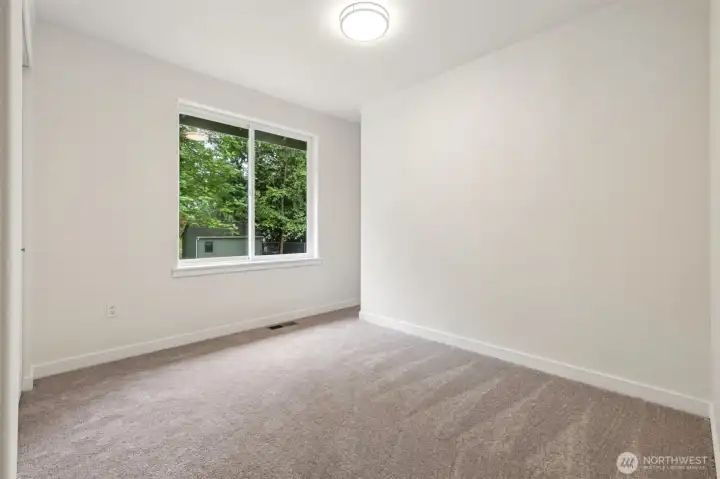 Bedroom #3 features fresh paint and plush carpeting for a cozy, restful atmosphere. Each room enjoys ample natural light and flexible layout options.
