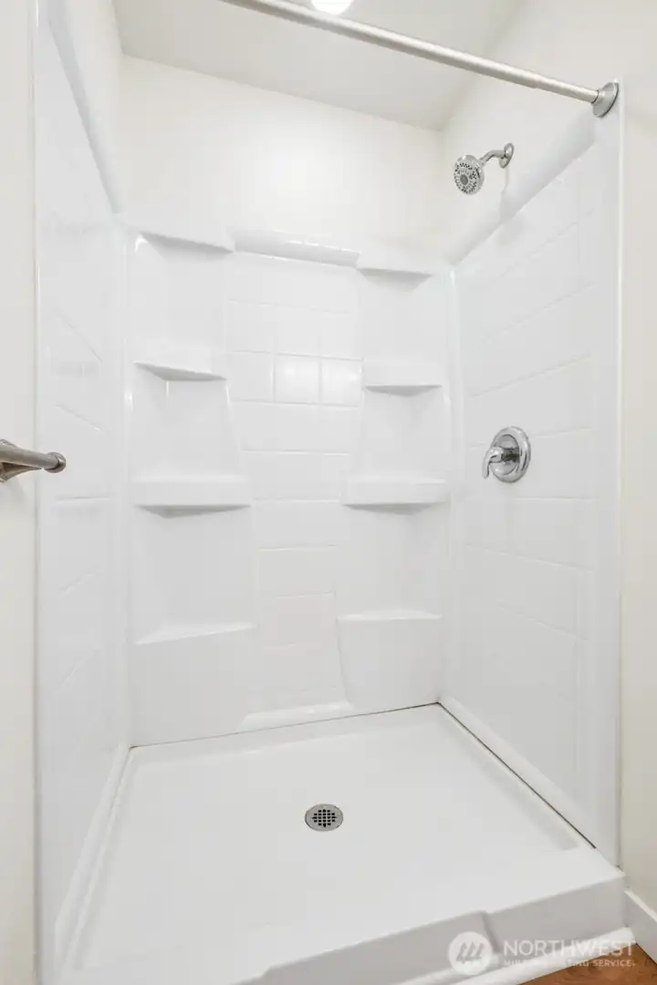 The studio’s ¾ bath features a newly installed shower enclosure that brings a fresh, modern feel to the space.