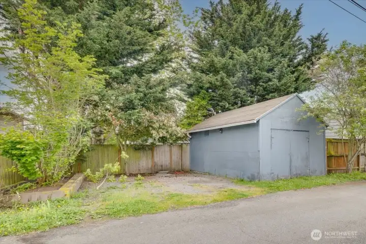 From alley showing spot for 2 cars next to garage