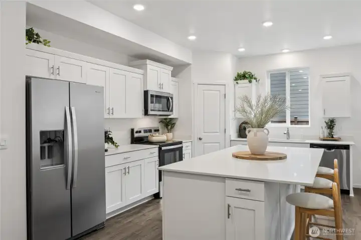 Generous quartz countertop island with bar seating. Photos are representative only and may display different colors and or upgrades.