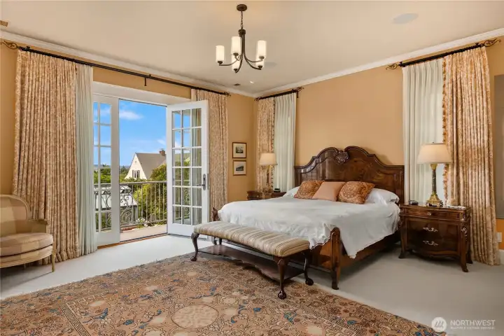 The primary suite with Juliet balcony overlooking the gardens and taking in the view of Port Townsend, Puget Sound and Mt Rainier