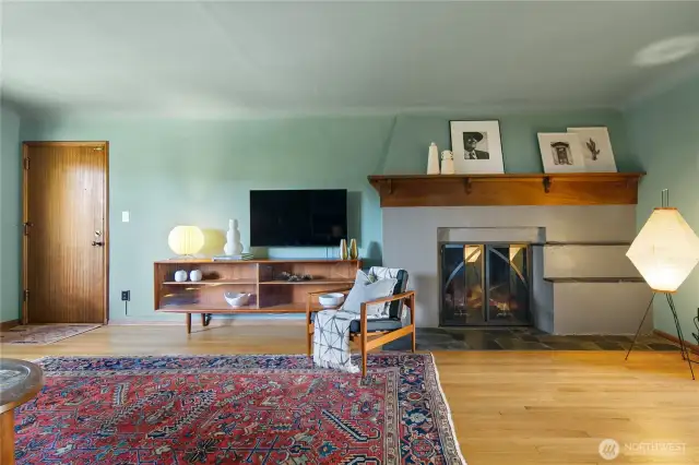 Gas logs fireplace has custom glass doors that echo the archways throughout the home.