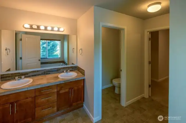 Double sink vanity in the en suite bath with rich cabinetry