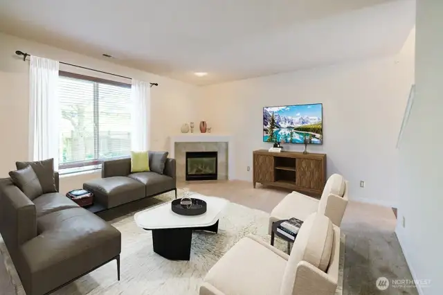 Living room overlooks the backyard and features corner gas fireplace. Photo virtually staged.