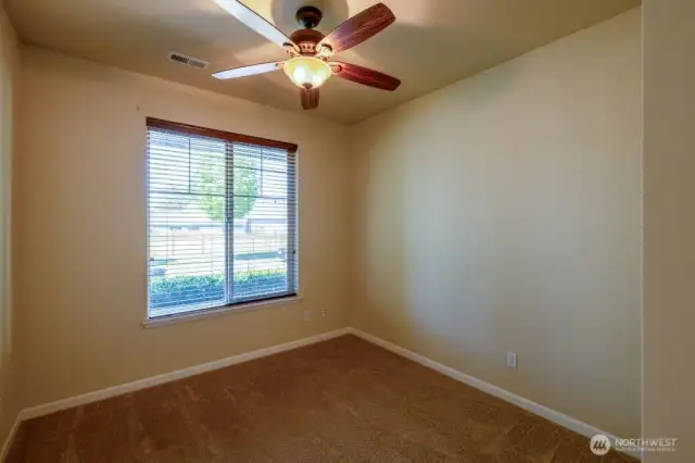 Den in the front of the home overlooks the front landscaping and features closet for extra storage.