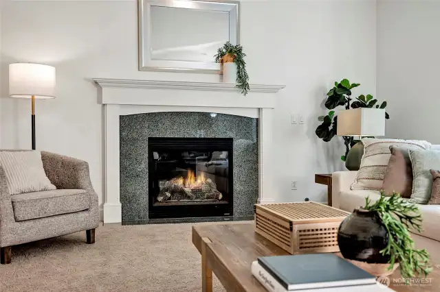 The cozy gas fireplace is framed in elegant granite and crisp white millwork.