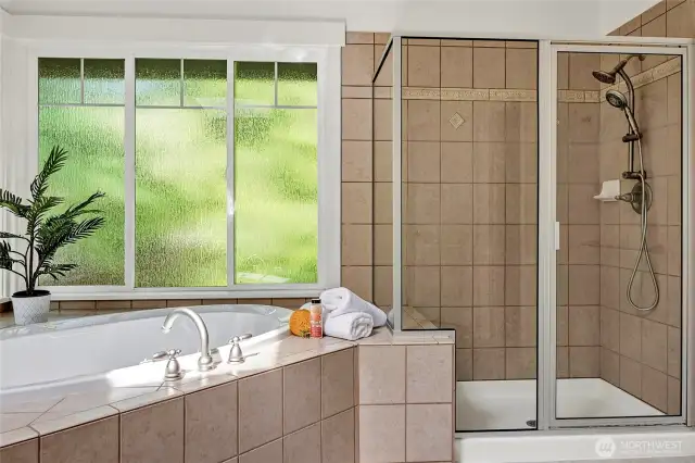 A large walk-in shower with elegant tile surround adds functionality and style.