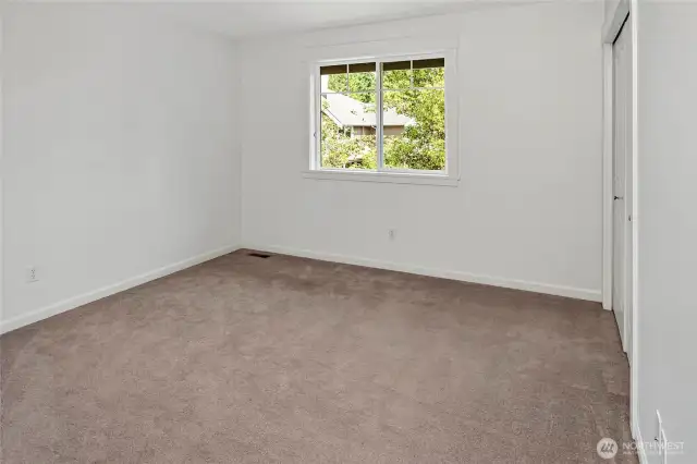 One of three secondary bedrooms-all are generously sized with large windows and neutral finishes
