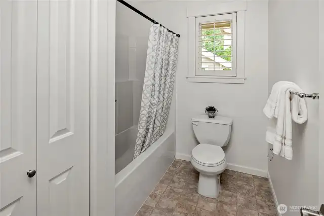 A separate room houses the tub/shower combo and toilet, offering added privacy and convenience. Thi window brings in filtered natural light.