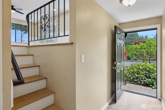 This shows front door entrance. stairs lead to living, dinning and kitchen. to the right is a hallway to bedrooms and to left goes down a few steps to lower level