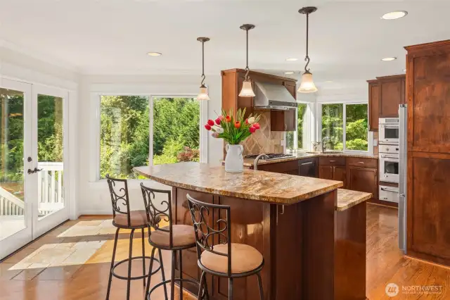 Kitchen with ample storage, stainless appliances, and a convenient eat-in bar.