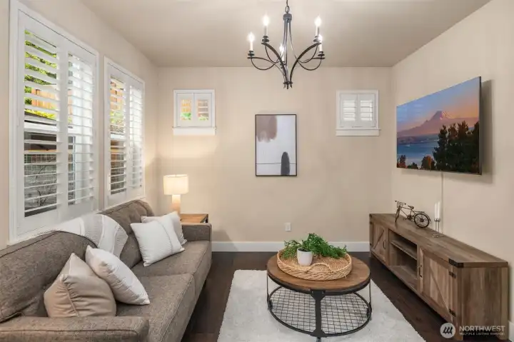 Space off the kitchen staged as a living room but could be formal dining room, office or playroom.