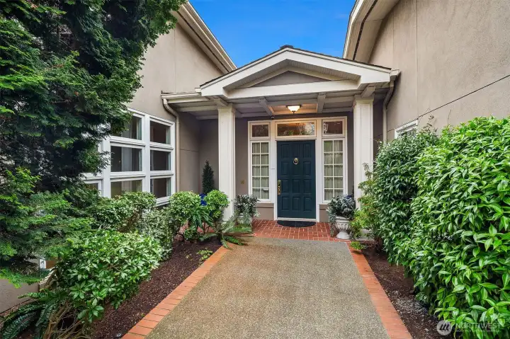 A thoughtfully landscaped path creates an inviting, serene, and tranquil journey into this magnificent home.