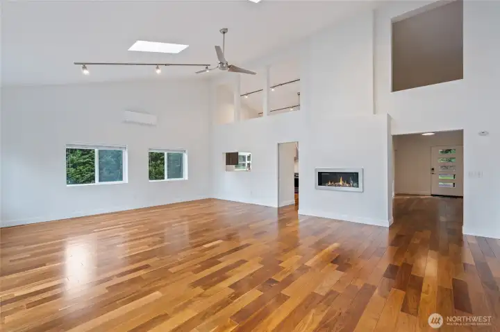 Great Room view to kitchen on left (with kitchen pass-through window), main entry and access to bedrooms / baths on right. Gas Fireplace. New blinds on double-pane windows.