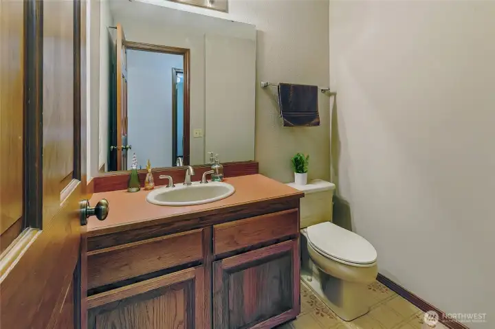 Half bath by laundry room, garage, and living room.