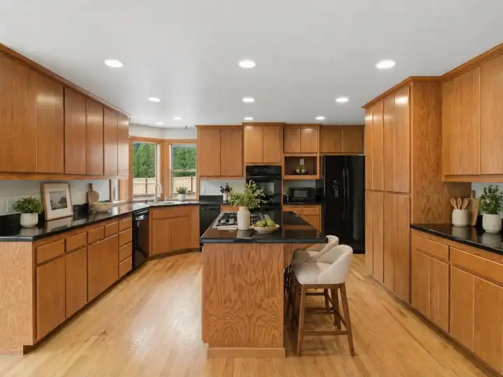 Kitchen with oak floors, granite counters and tons of space for storage (Virtual staging to show potential)