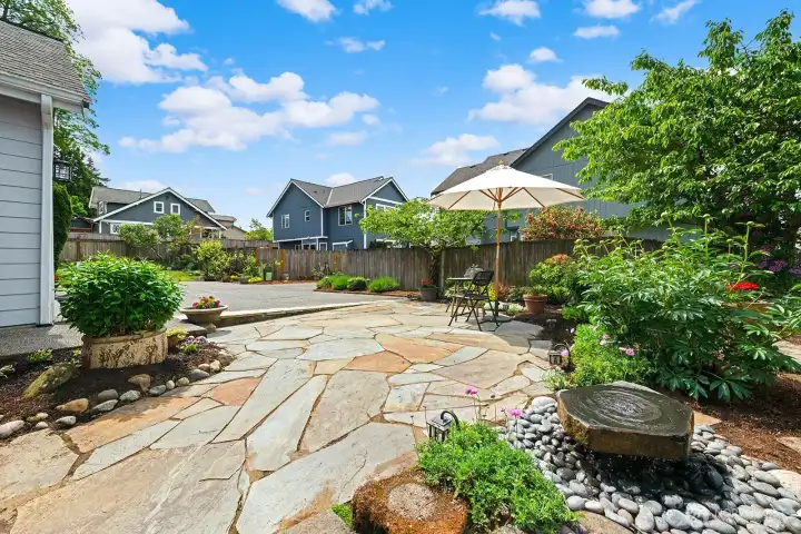 Expansive flagstone patio with stone fountain & mature landscaping. Expansive flagstone patio with stone fountain & mature landscaping.