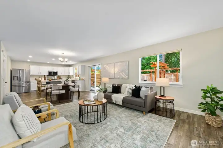 Spacious open-concept family room flows to kitchen, deck, & pine tree views. Spacious open-concept family room flows to kitchen, deck, & pine tree views.