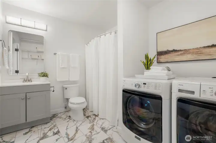 Lower level bath with washer and dryer.