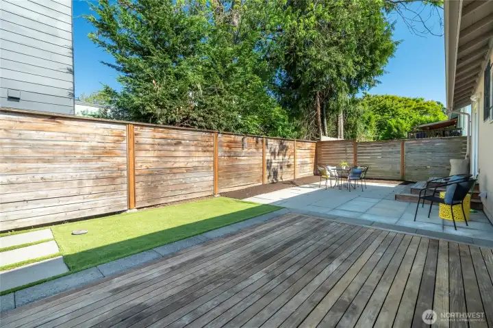 Large backyard with pavers, deck and turf.