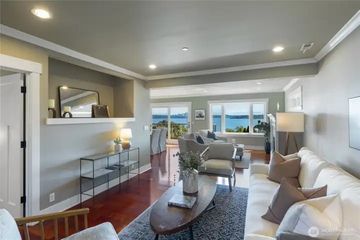 Comfortably sized main level living area with Lake Washington and skyline views. Thoughtfully designed with traditional crown moldings, baseboards and craftsman attention to detail, coupled with warm Mahogany hardwood floors throughout, the design aesthetic seamlessly blends elegance and comfort.