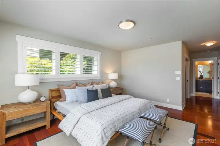 Bright and generously sized primary suite bedroom with Mahogany hardwood floors.