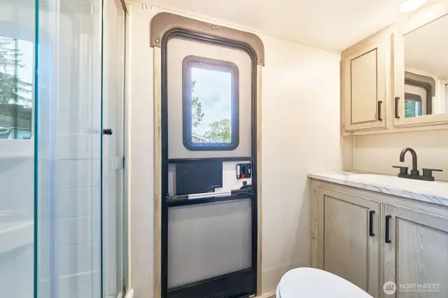 Bathroom has a walk-in shower and rear entry door