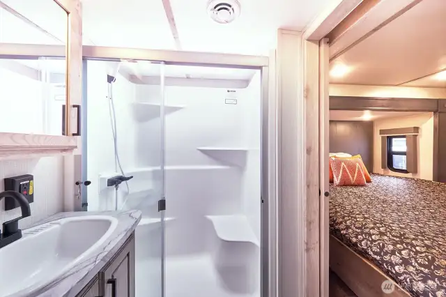 Bathroom has large walk-in shower with a bright skylight.