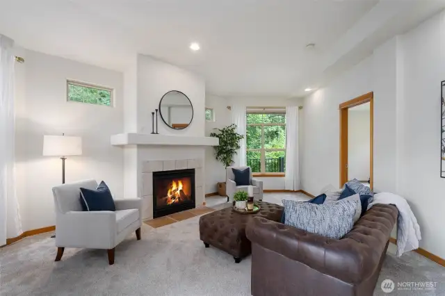 The living room is anchored by a gas fire place and tons of windows that look over the greenspace.