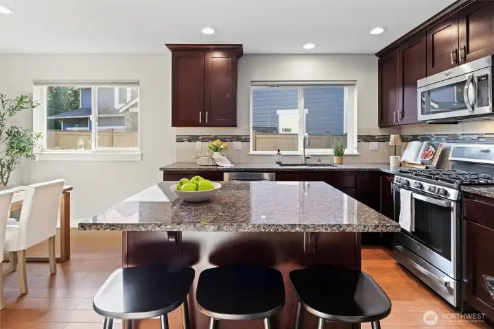 Kitchen with granite countertops, island seating, and walk-in pantry