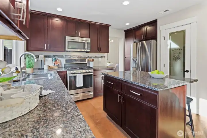 Kitchen with granite countertops, island seating, and walk-in pantry