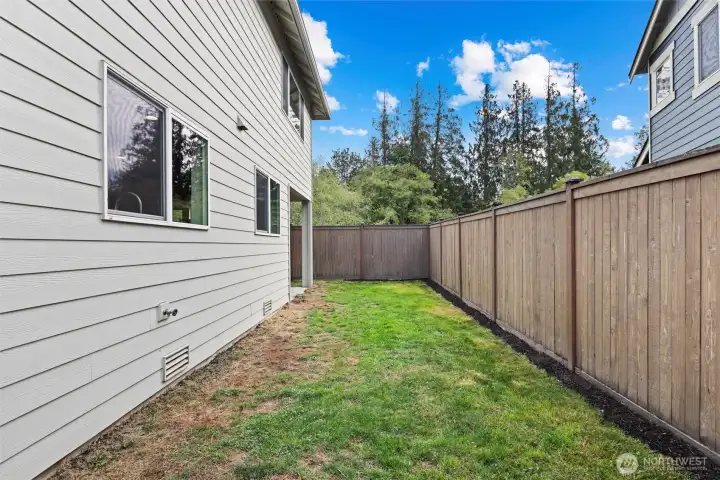 Backyard with covered entertaining patio and play structure